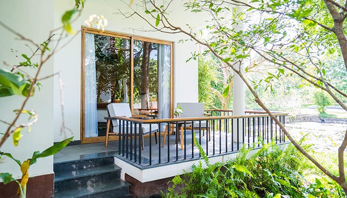Premium Deluxe Room balcony opening to the forest at Alba Wellness Valley Hue